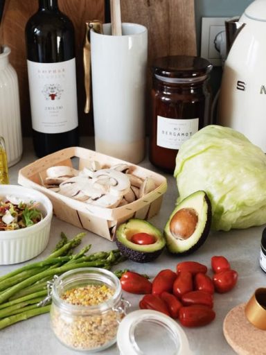 Assorted healthy food and vegetables set locating on gray countertop next to various utensils and appliances during cooking in stylish kitchen