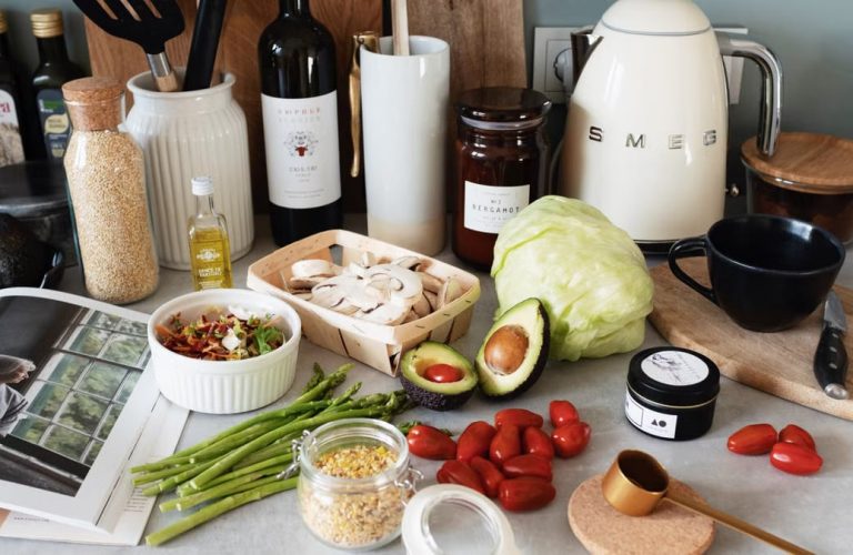 Assorted healthy food and vegetables set locating on gray countertop next to various utensils and appliances during cooking in stylish kitchen